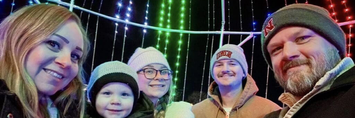 A photo of the Jenkins family in front of Christmas lights