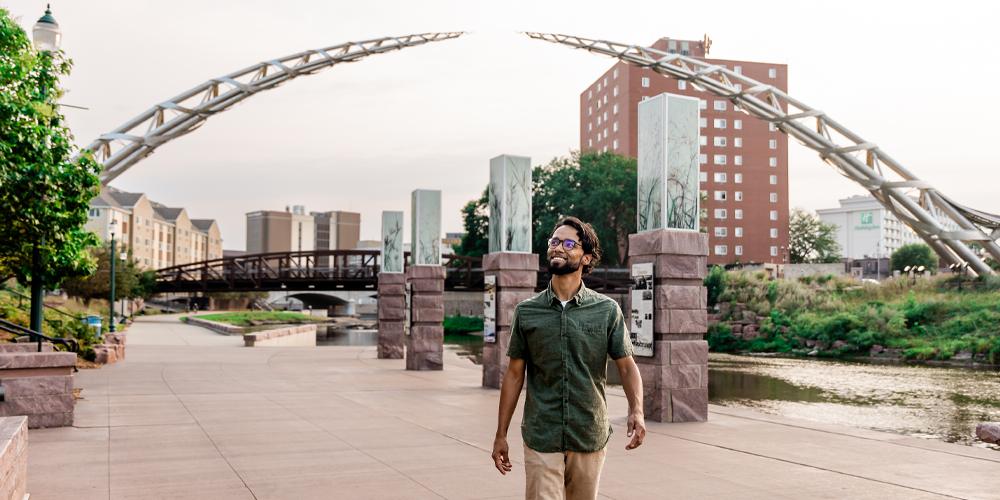 A photo of a man walking below the Arc of Dreams in Sioux Falls, SD
